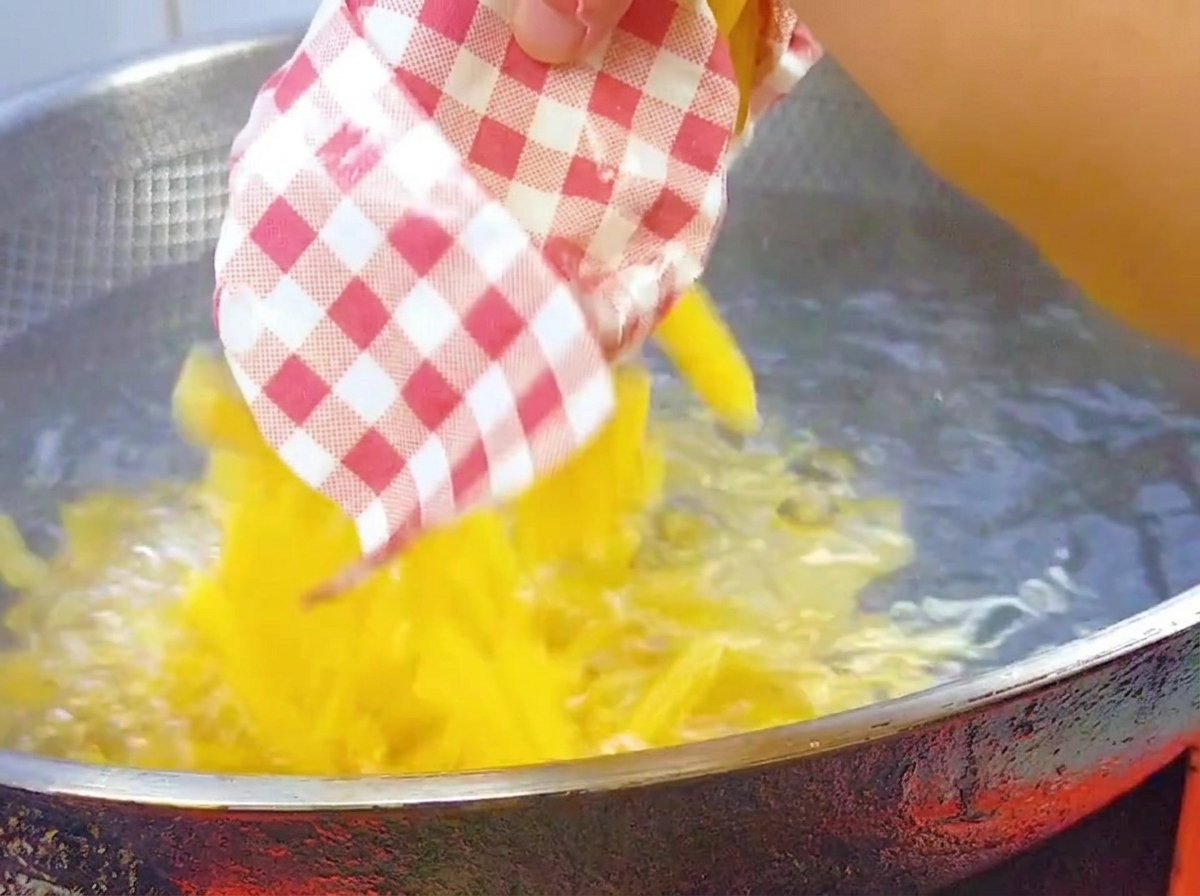 Des pennes sèches versées dans un grand wok deau bouillante salée.