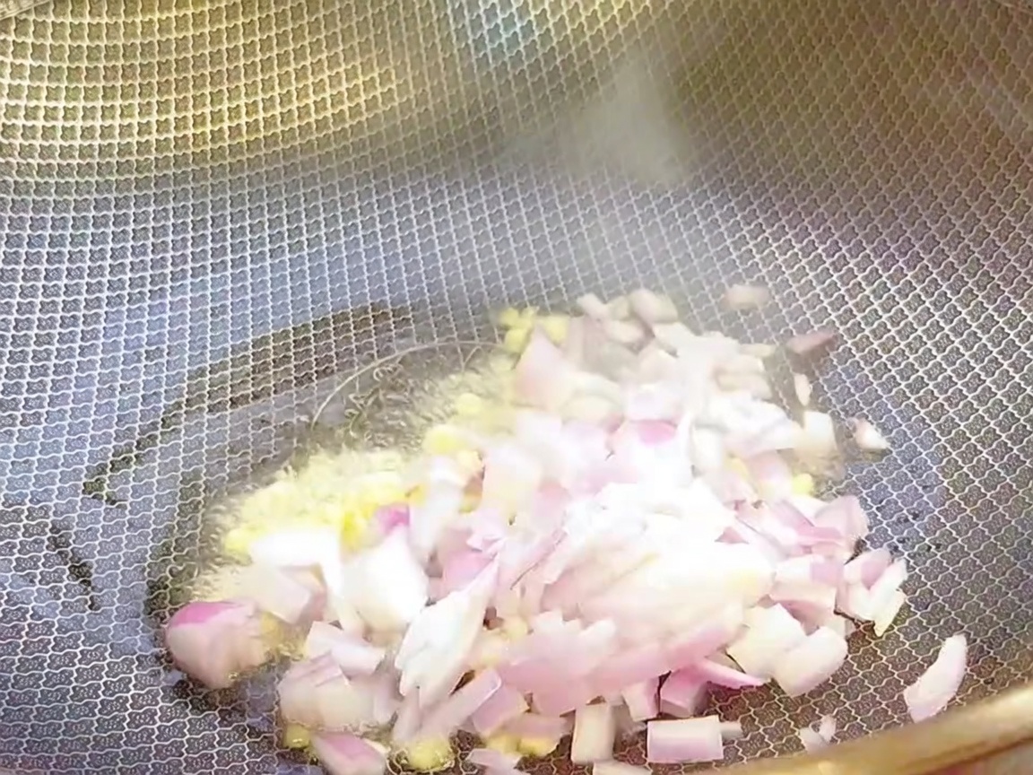 De lail haché et de loignon émincé sautés dans un wok chaud avec de lhuile.