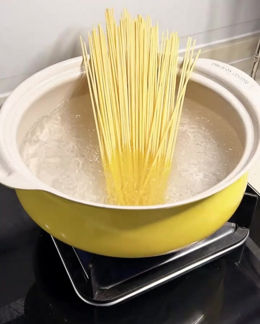 Spaghetti plongeant dans une casserole deau bouillante.