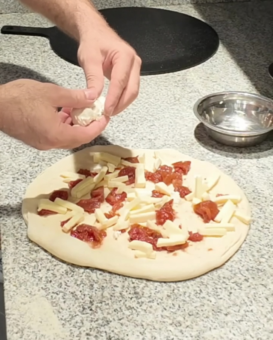 Fromage de chèvre frais déposé sur la pizza.