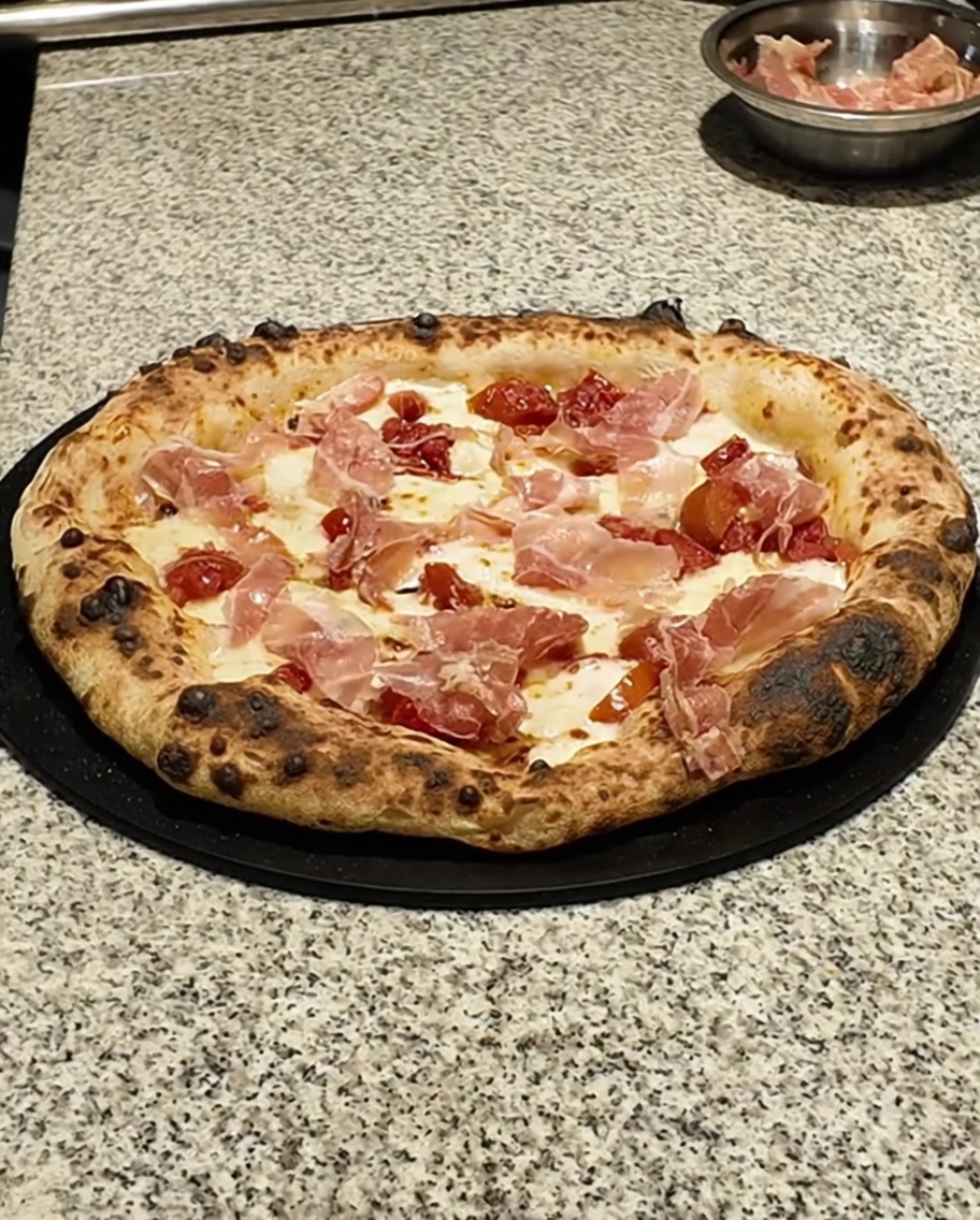 Gros plan sur des feuilles de thym frais saupoudrées sur la pizza cuite.