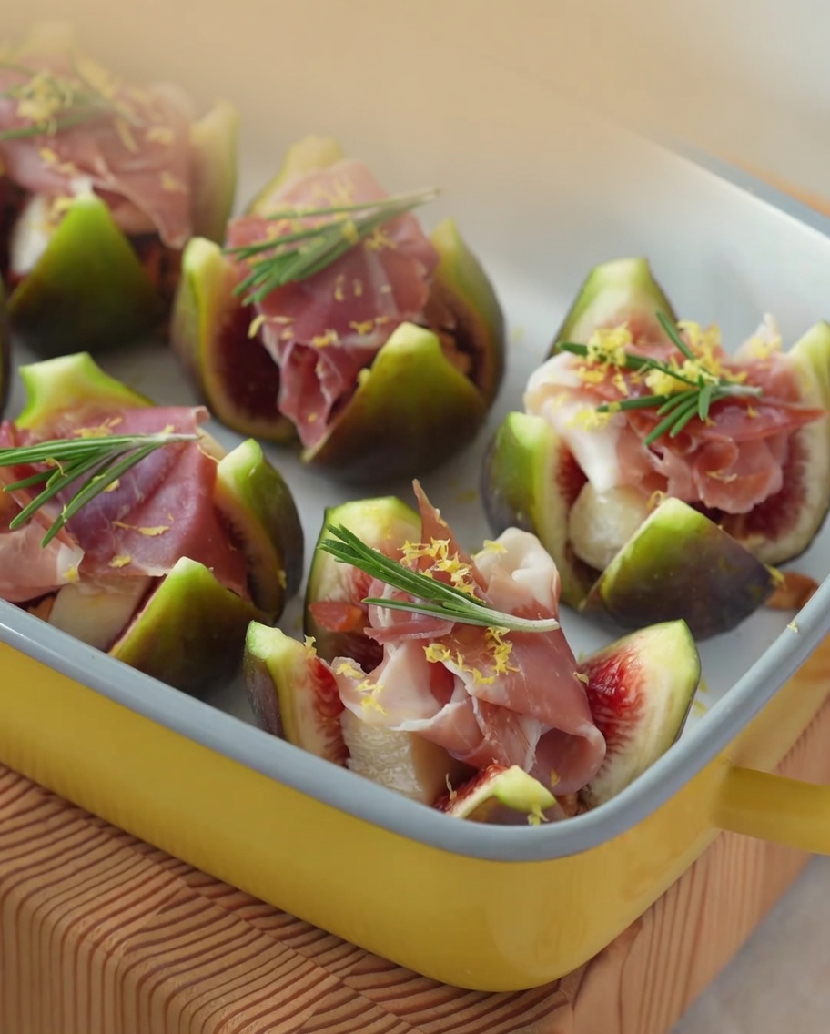 Gros plan sur du miel versé sur des figues farcies au Brie et au jambon.