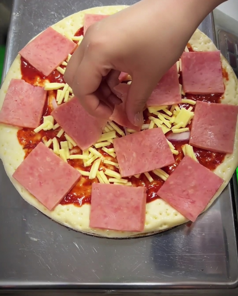 Gros plan dune pizza garnie de maïs, de poivron vert et de champignons sur le jambon.