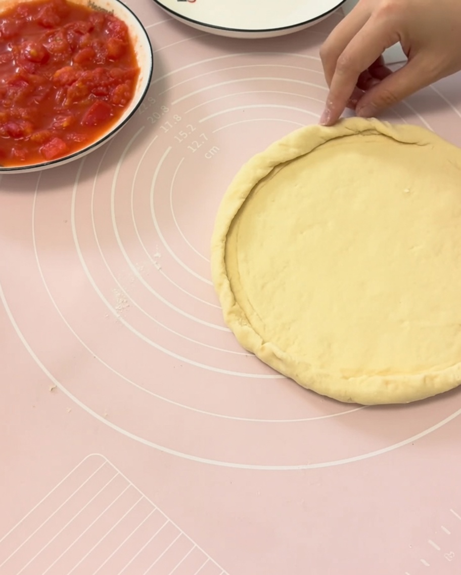 Mains repliant les bords de la pâte sur une assiette.