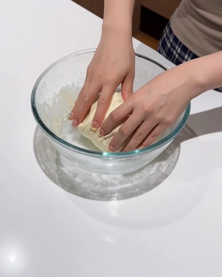 Une boule de pâte lisse reposant dans le bol.