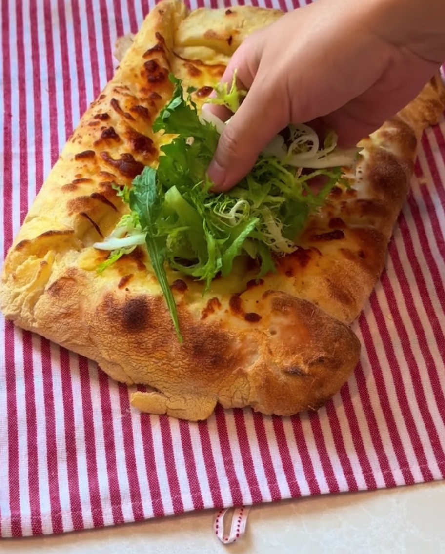 Jeunes pousses et tranches fines de jambon prosciutto déposées sur la croûte de la pizza cuite.