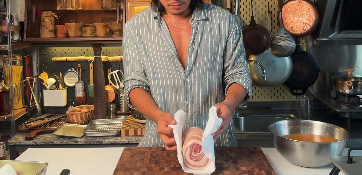 Essuyer une poitrine de porc ficelée et marinée avec des essuie-tout.