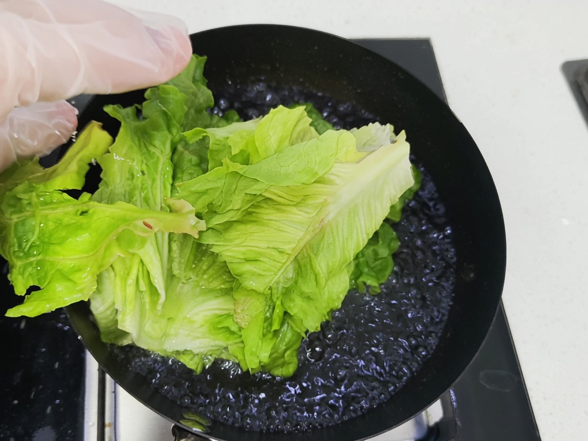 Des légumes verts à feuilles frais plongés dans une casserole deau bouillante.