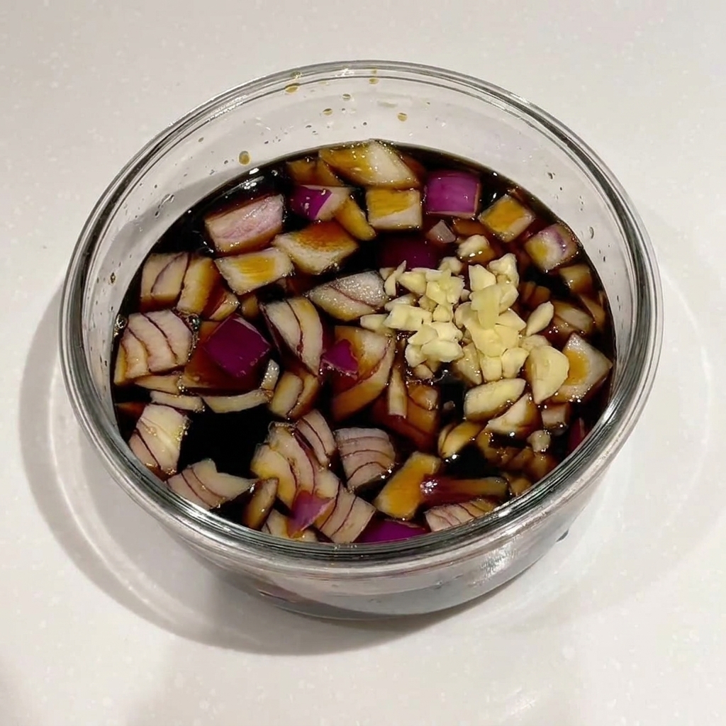 Un mélange doignons rouges, dail, doignons nouveaux et de graines de sésame ajouté à une marinade à la sauce soja.