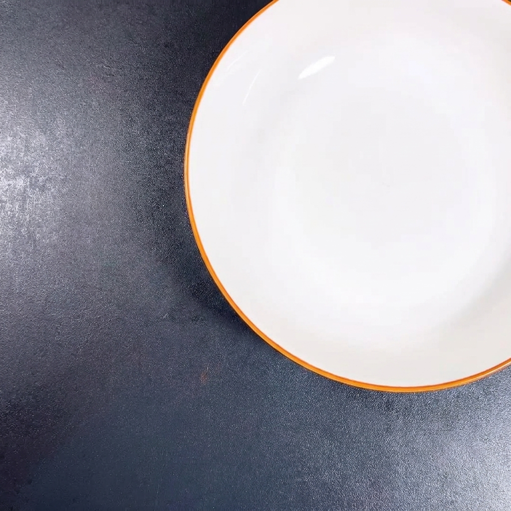 Un bol blanc contenant de lail fraîchement haché et des oignons verts ciselés.