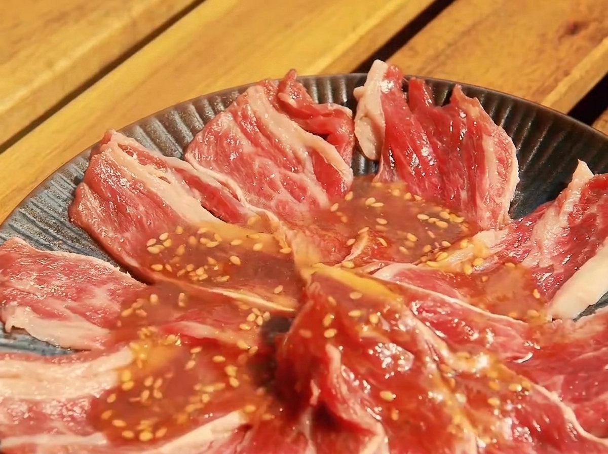 Fines tranches de bœuf dans un plat, enrobées de sauce Yakiniku.