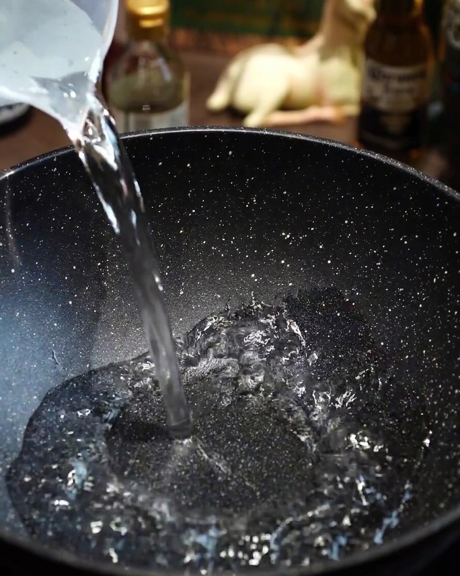De fines tranches de bœuf Wagyu ajoutées avec précaution dans leau bouillante dune poêle.