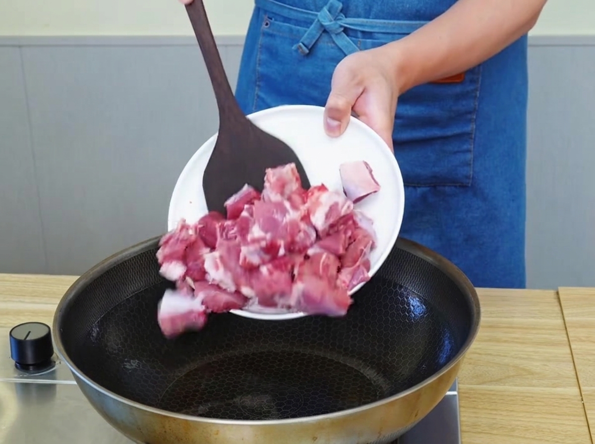 Des morceaux de bœuf qui dorent dans une poêle avec de lhuile chaude, développant une croûte dorée.