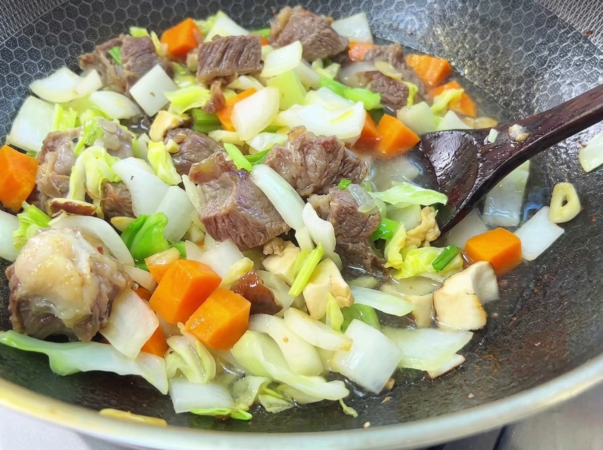 De leau versée sur le bœuf et les légumes dans une casserole, prêts pour un long mijotage.