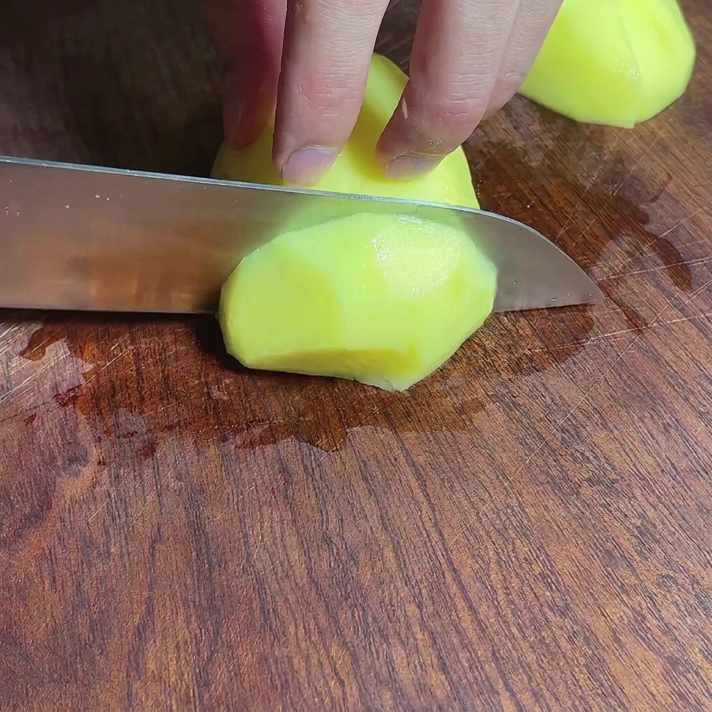 Morceaux de pommes de terre hachées sur une planche à découper en bois.