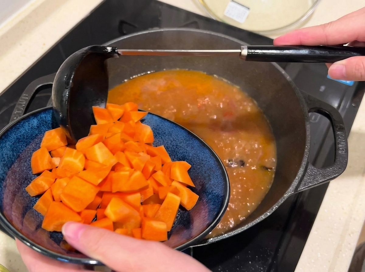 Carottes en dés ajoutées dans une poêle de bouillon de bœuf frémissant.