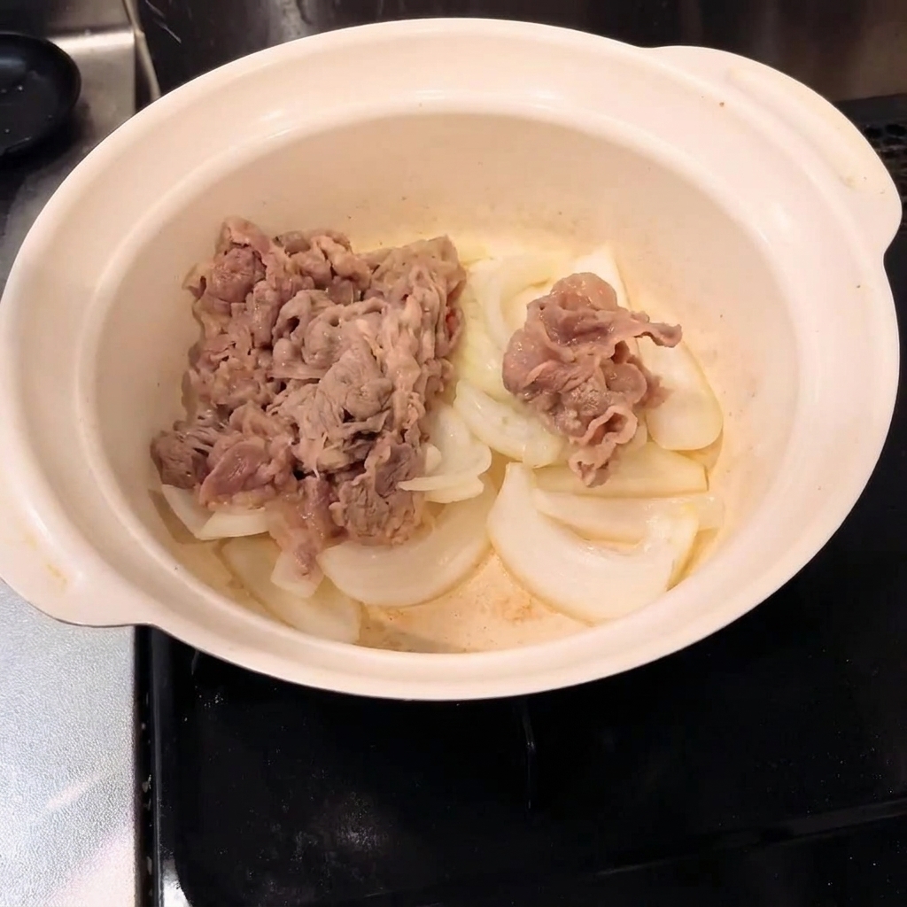 Bœuf blanchi mélangé aux oignons dans une casserole.