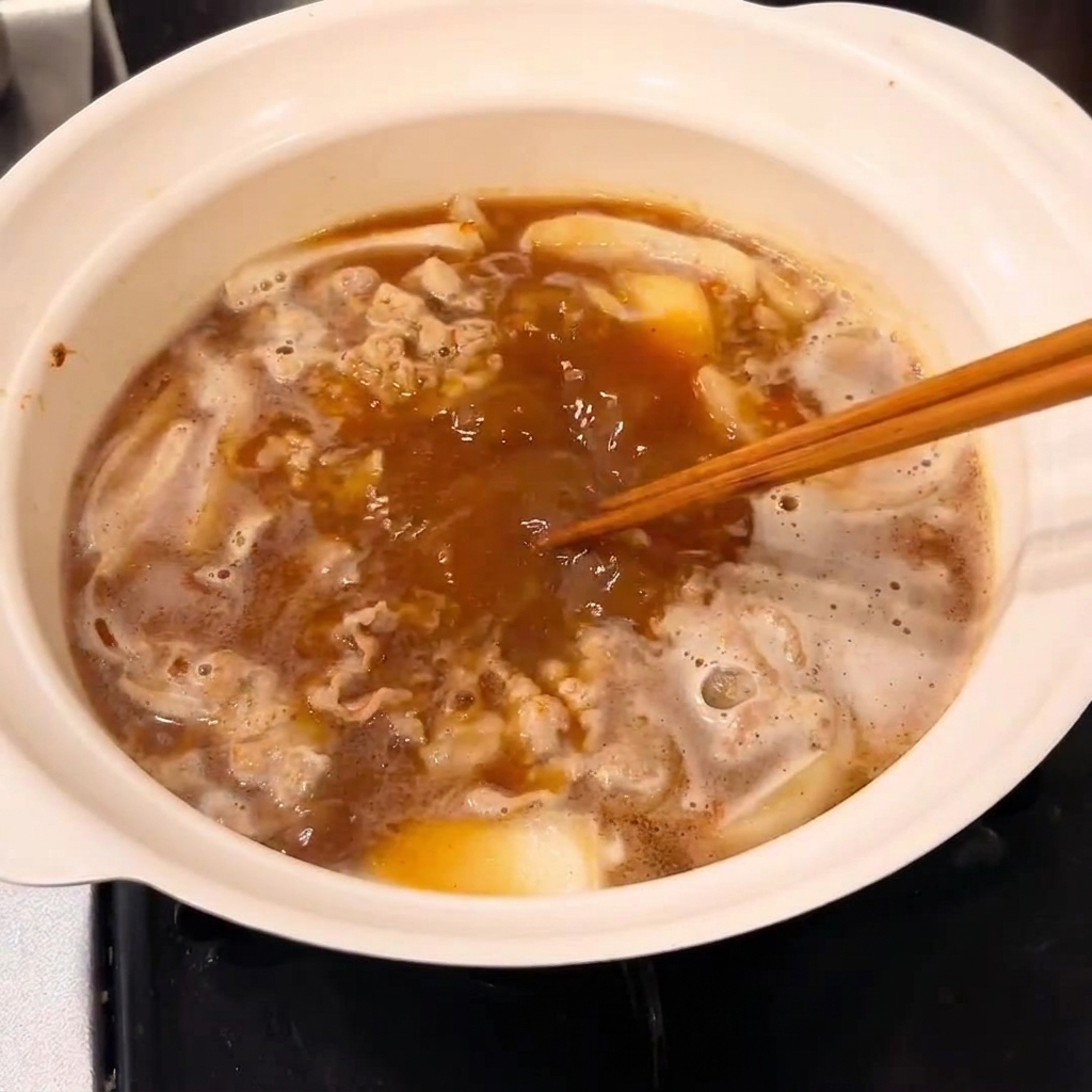 Une tablette de roux de curry ajoutée à la casserole pour épaissir la sauce.