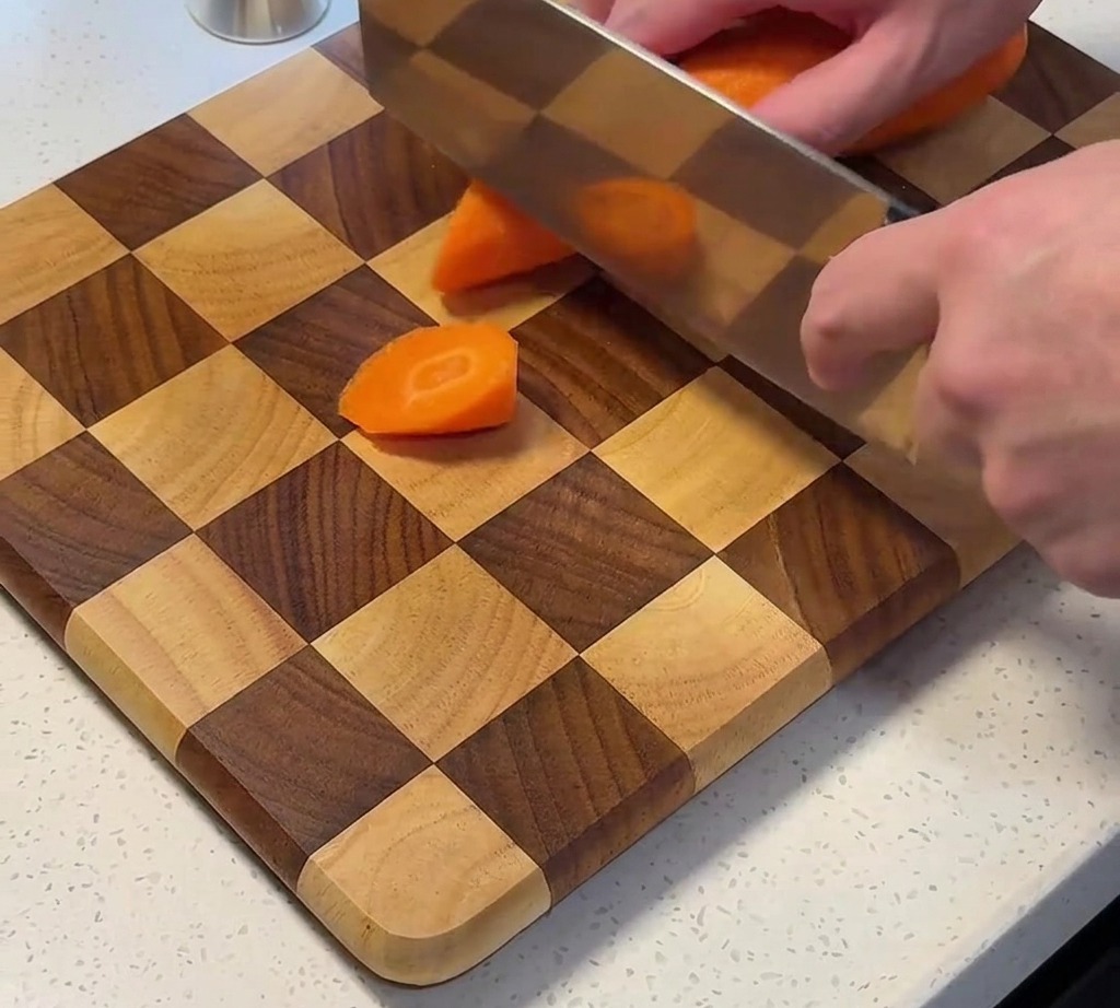 Carottes fraîches coupées en morceaux sur une planche à découper.