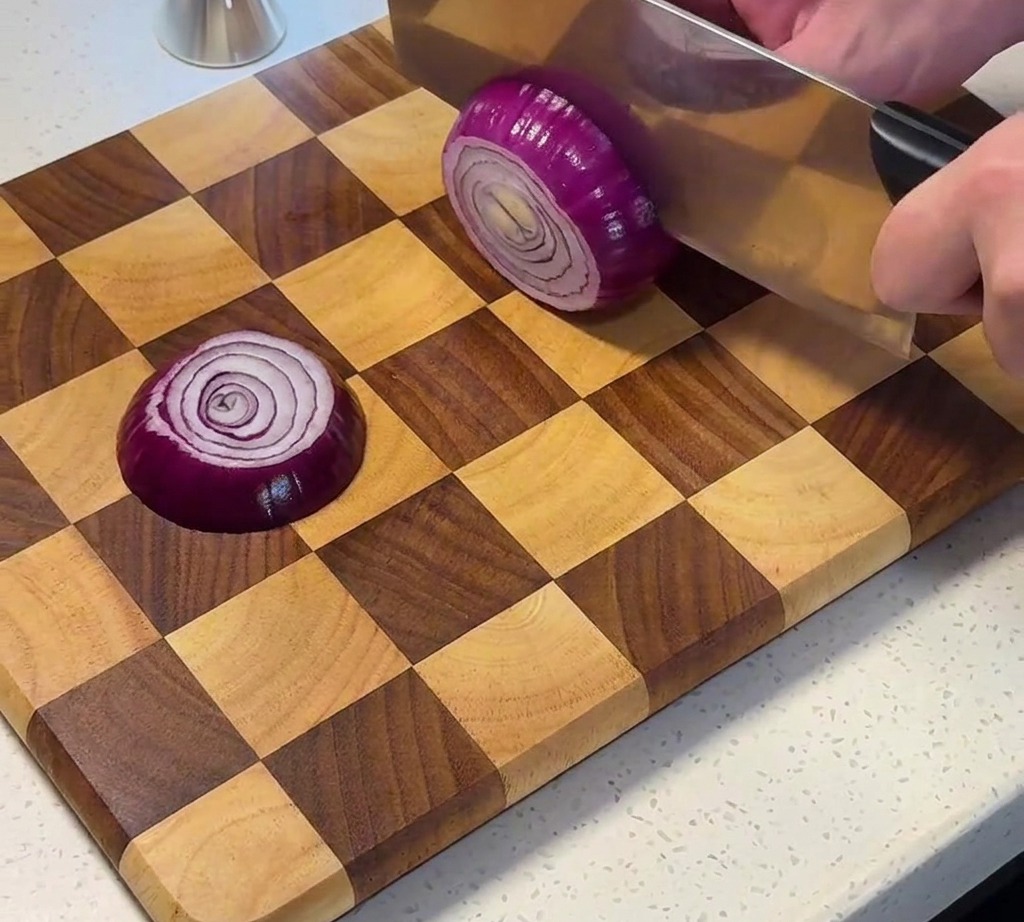 Oignon rouge émincé sur une planche en bois.