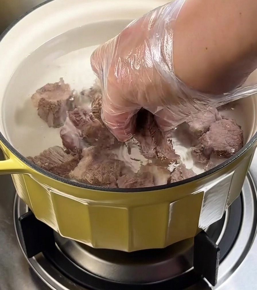 Casserole de poitrine de bœuf mijotant sur le feu sous un couvercle.