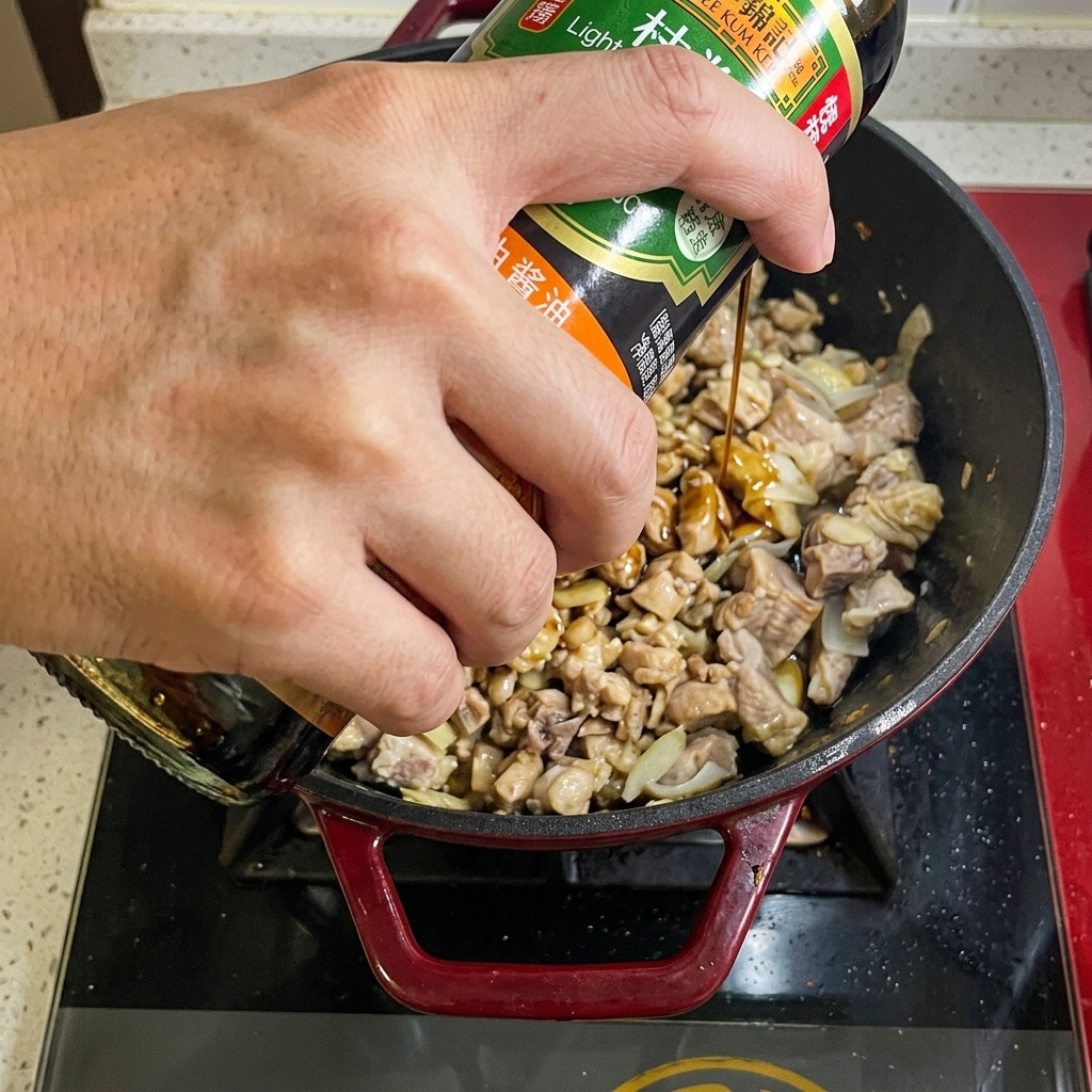 Sauce soja versée depuis une bouteille dans la casserole de bœuf.