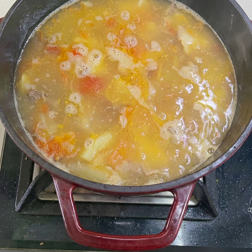Eau bouillante versée dans la casserole avec le bœuf et les légumes.