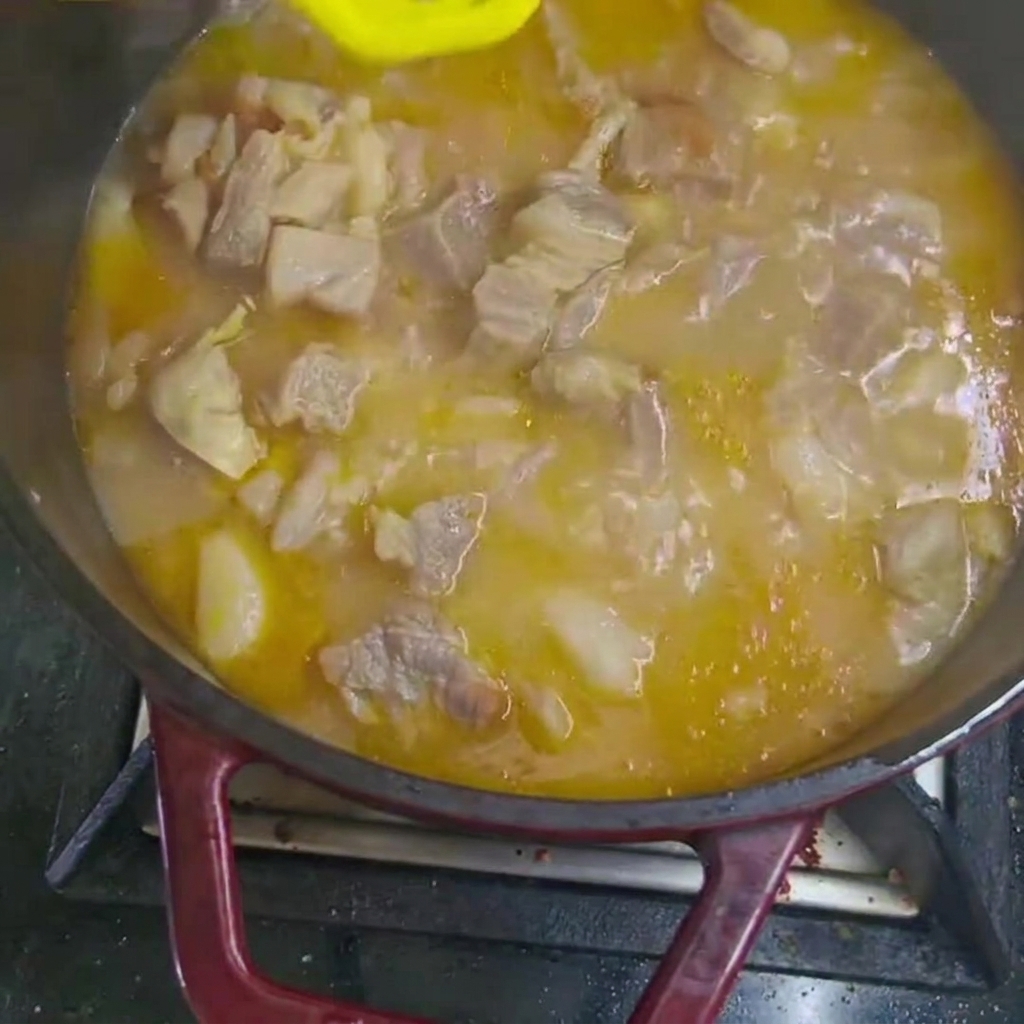 Morceaux de carotte et de pomme de terre ajoutés au ragoût de bœuf qui mijote.
