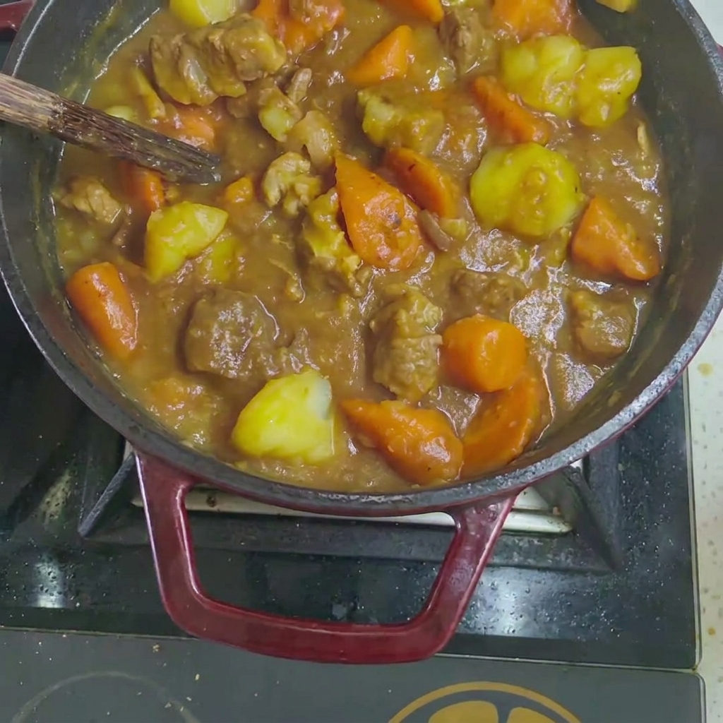 Cubes de curry solides ajoutés au ragoût de bœuf et légumes cuits.