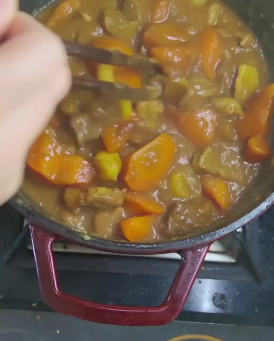 Remuer la sauce au curry épaisse avec un ustensile en bois.