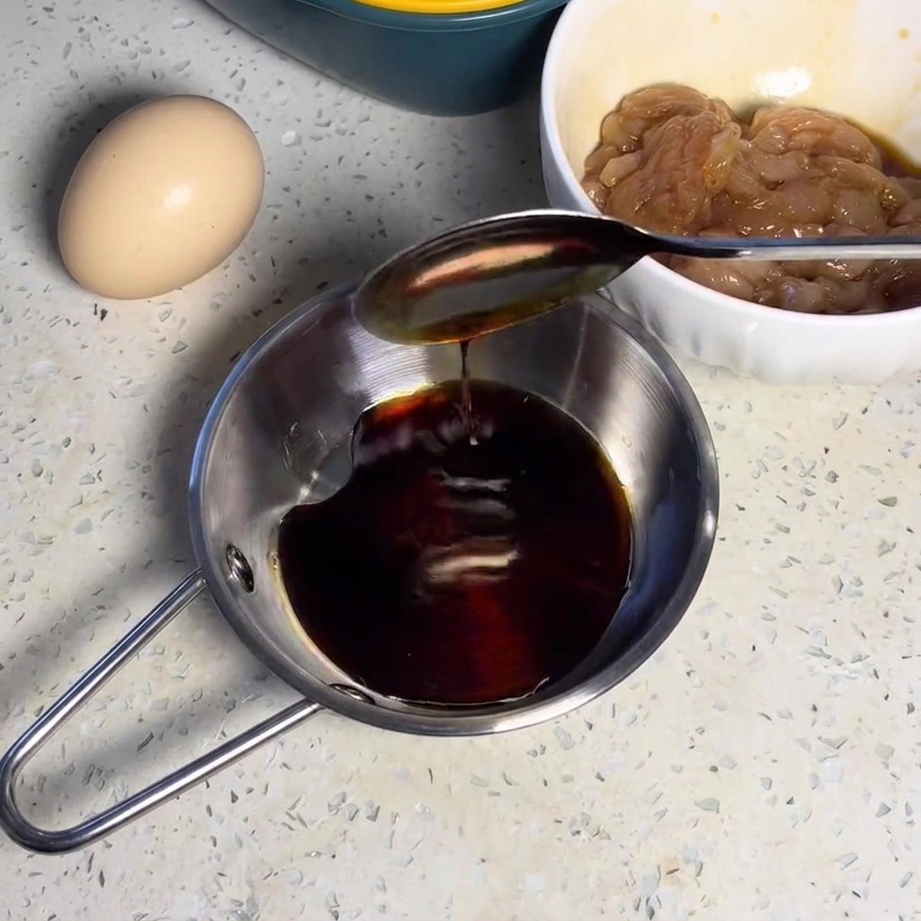 Mélange de sauce sombre remué dans un petit bol en métal.