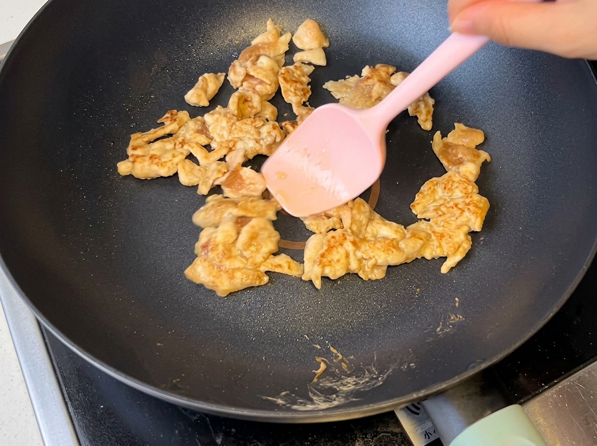 Oignons émincés sautés avec le poulet dans la poêle.