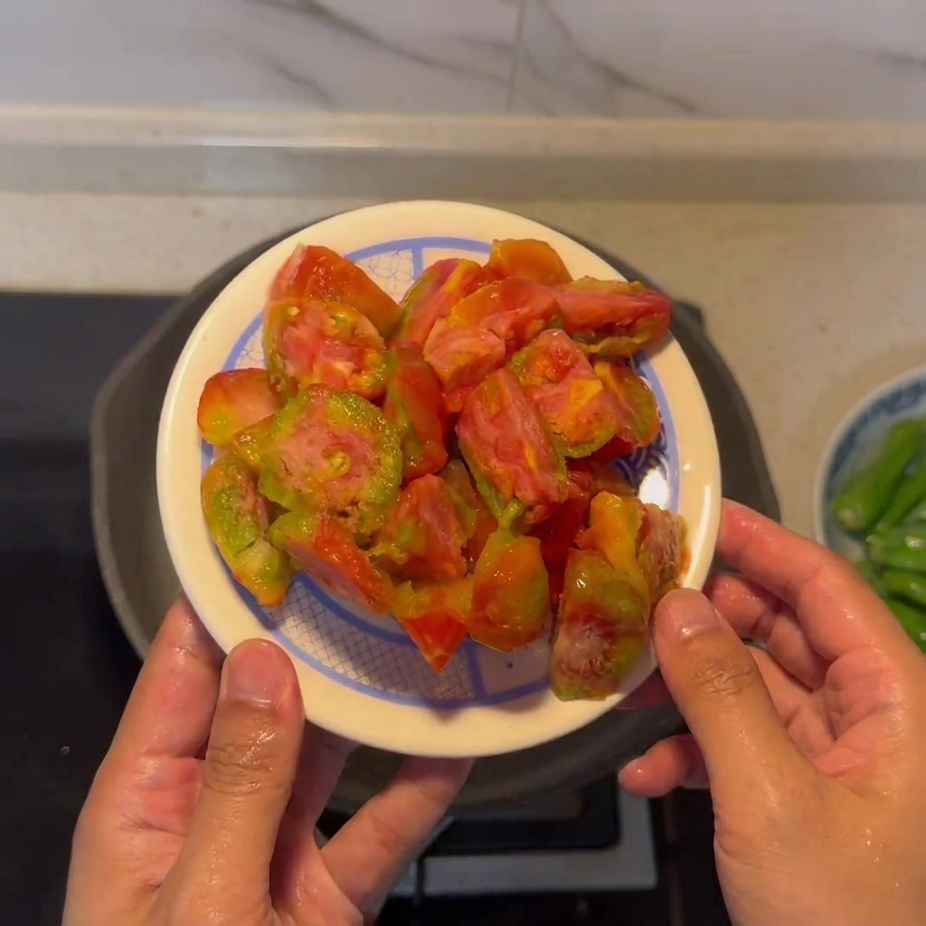 Une assiette de tomates pelées et coupées en morceaux, prêtes à être cuisinées.