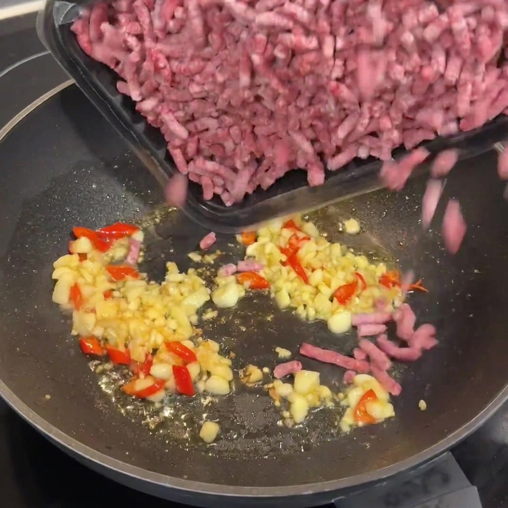 Bœuf haché Wagyu ajouté dans le wok chaud avec lail et les piments sautés.