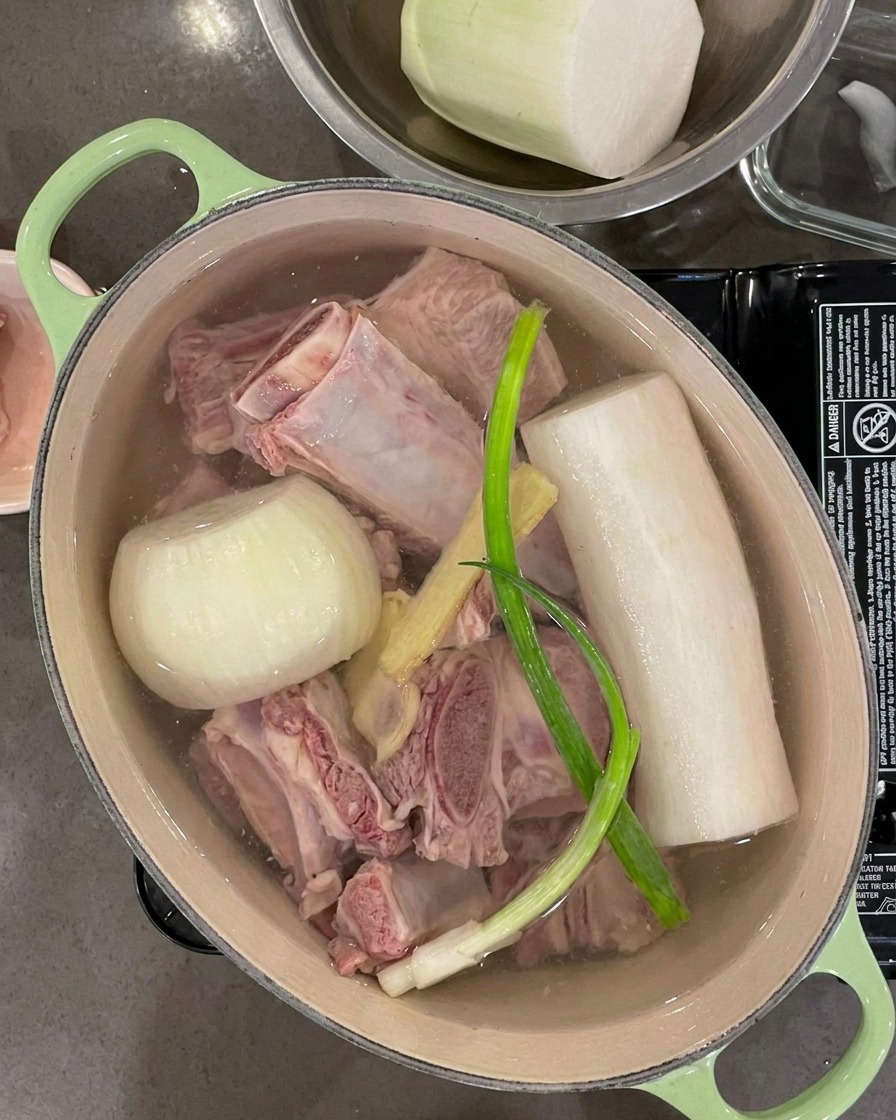 Eau versée dans la marmite, recouvrant complètement les côtes, les légumes et les aromates.