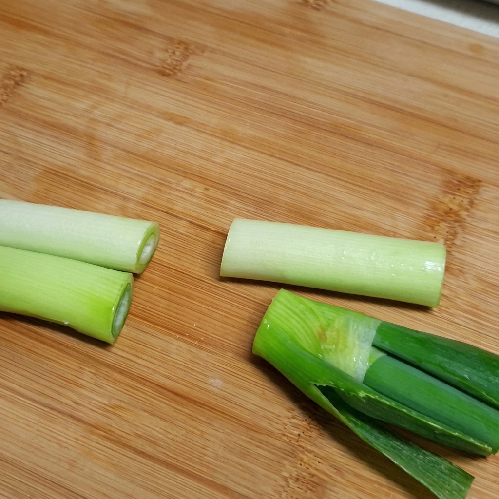 Ingrédients, dont les travers de bœuf, le radis et des morceaux doignon, ajoutés dans une grande marmite remplie deau.