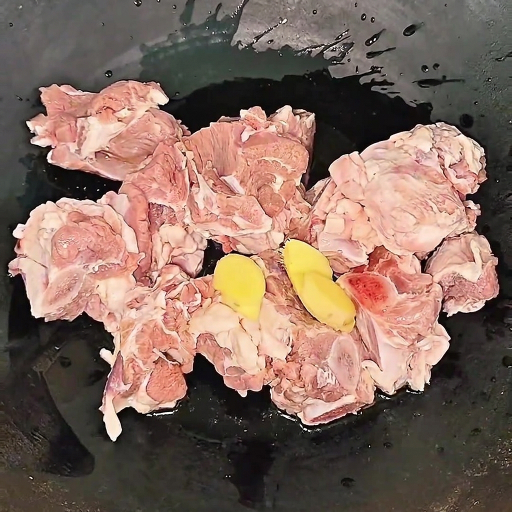 Travers de bœuf mijotant dans une casserole avec des tranches de gingembre et du vin de cuisine pendant le processus de blanchiment.