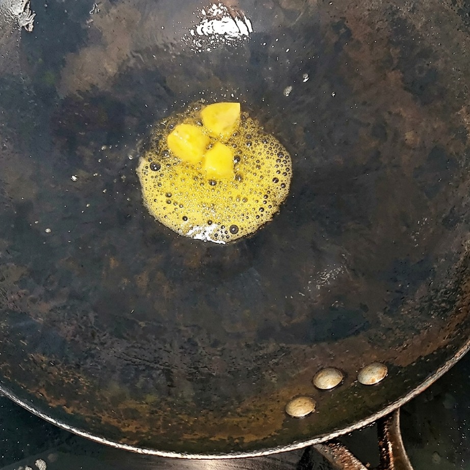 Travers de bœuf et tranches de gingembre sautant dans un wok chaud.