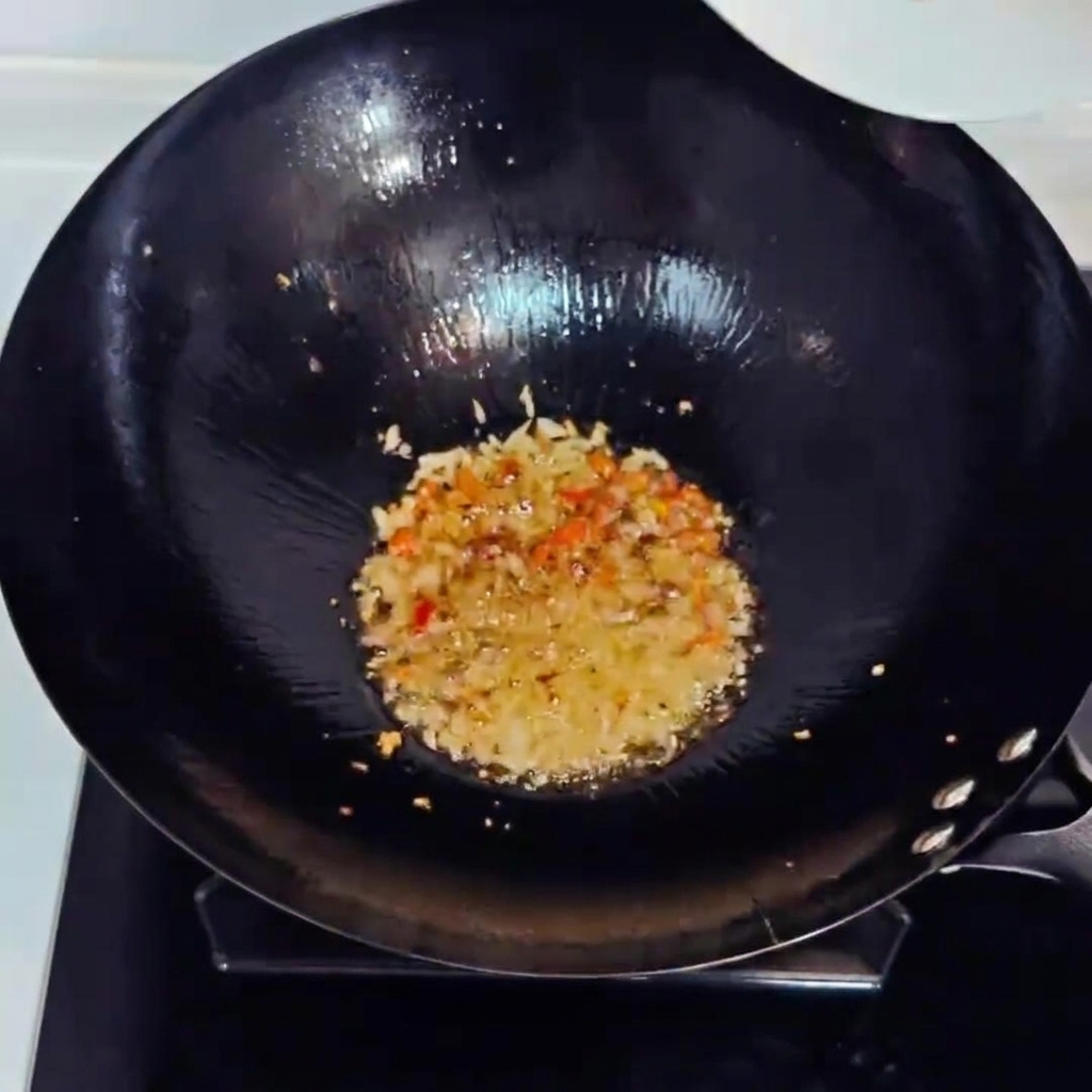 Kimchi haché et jambon en dés sautés dans un wok avec des aromates.