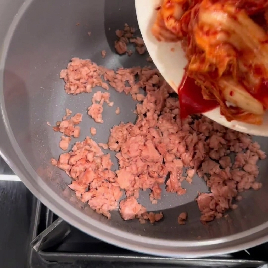 Kimchi ajouté dans la casserole contenant le Spam revenu.