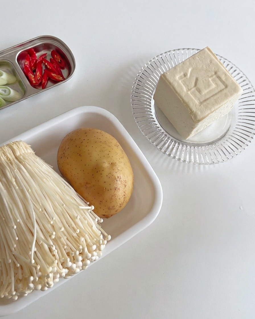 Blocs de tofu blanc ferme coupés en tranches régulières sur une planche en bois.