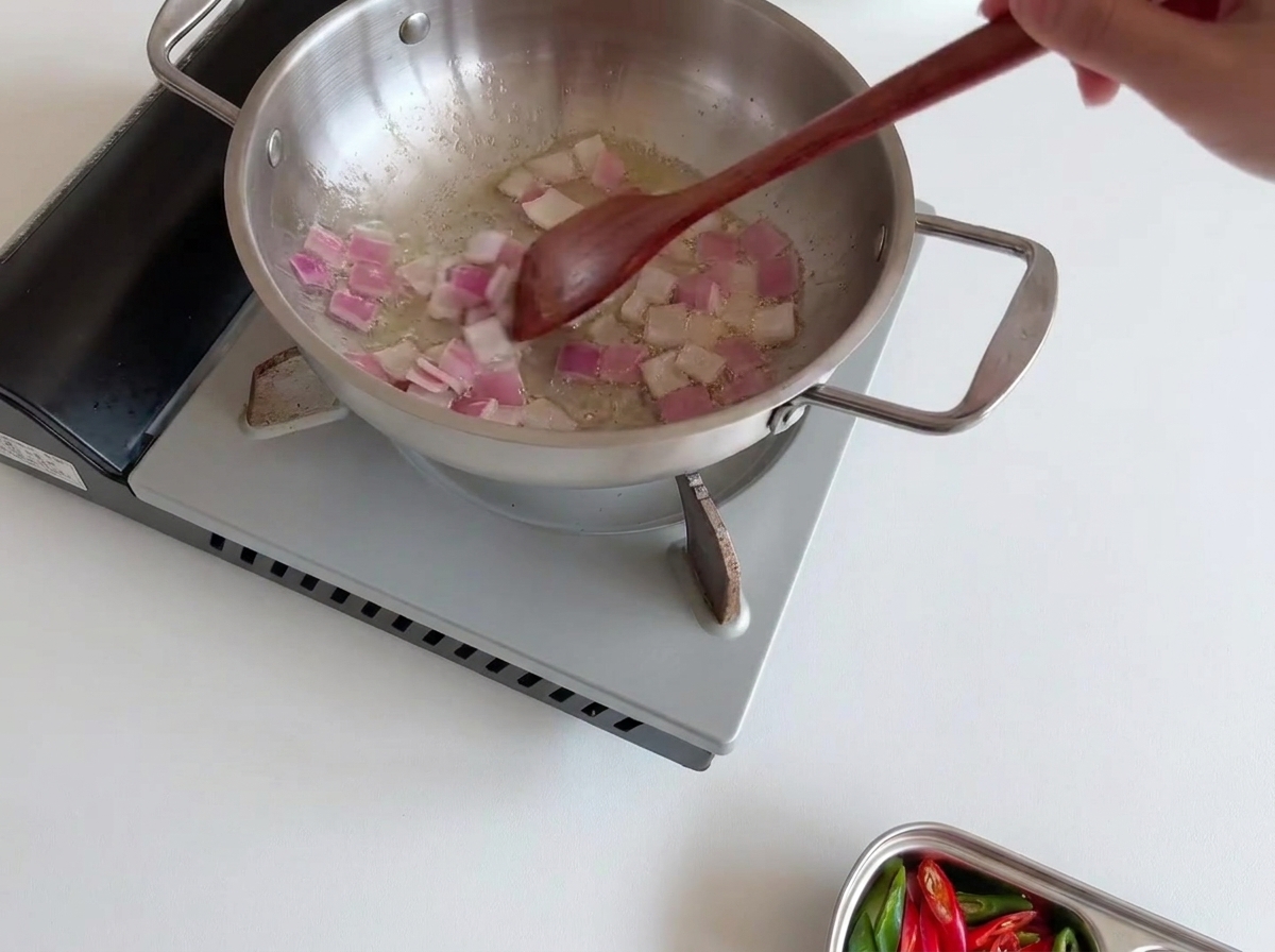 Couche de champignons enoki blancs disposée sur les oignons sautés.