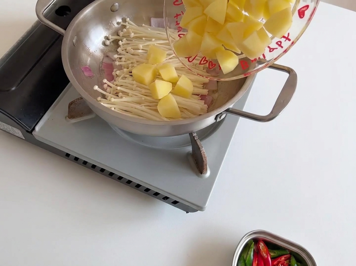 Morceaux de pommes de terre jaunes disposés sur les champignons.