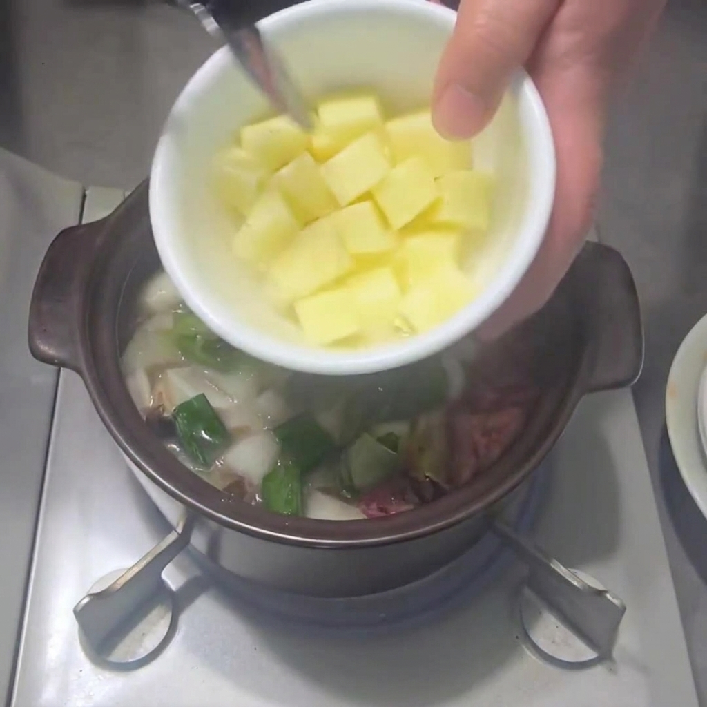 Pommes de terre coupées en dés ajoutées dans la casserole avec les autres légumes.