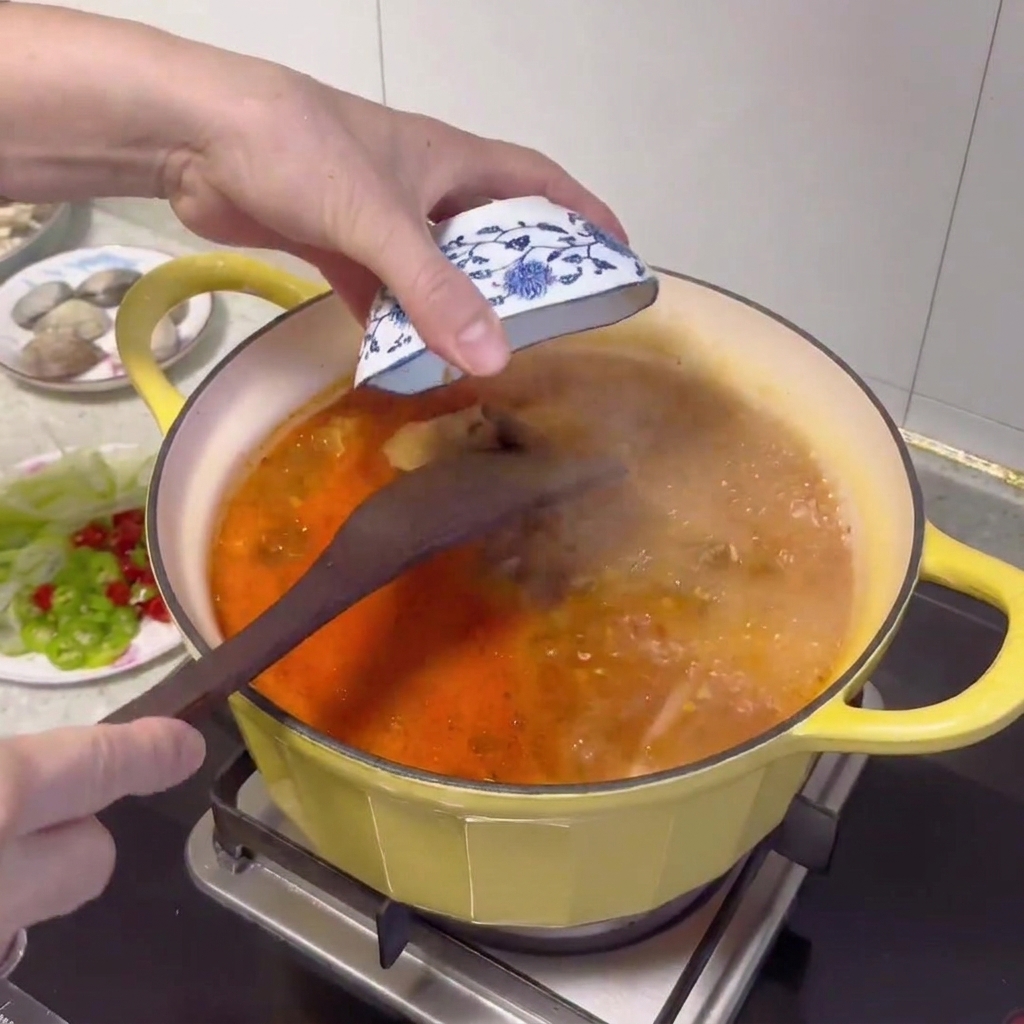 Cuillère en bois incorporant la pâte de soja dans le bouillon frémissant.
