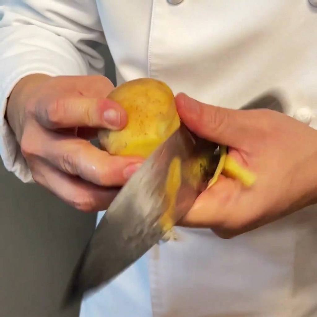 Dés de pommes de terre uniformes prêts à être cuisinés sur une surface en bois.
