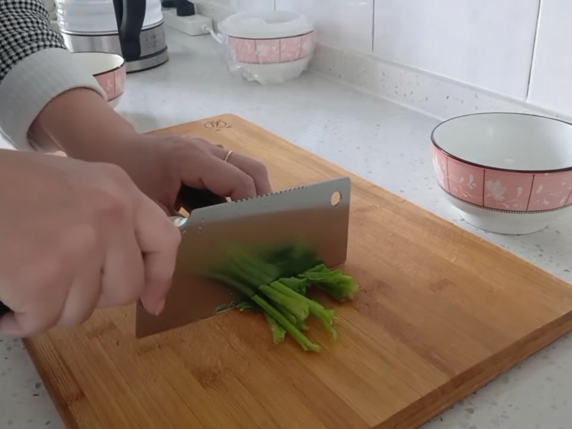 Feuilles dépinards frais coupées en morceaux sur une planche à découper.