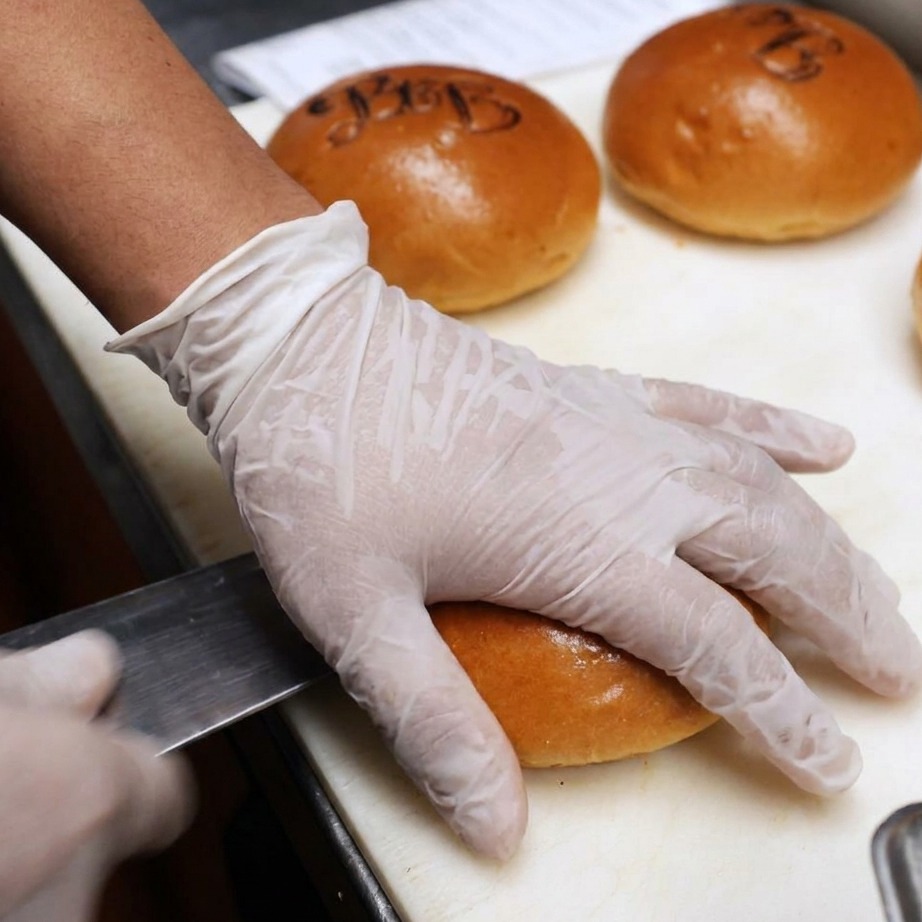 Pains à burger coupés en deux et recouverts de beurre pour le grill.