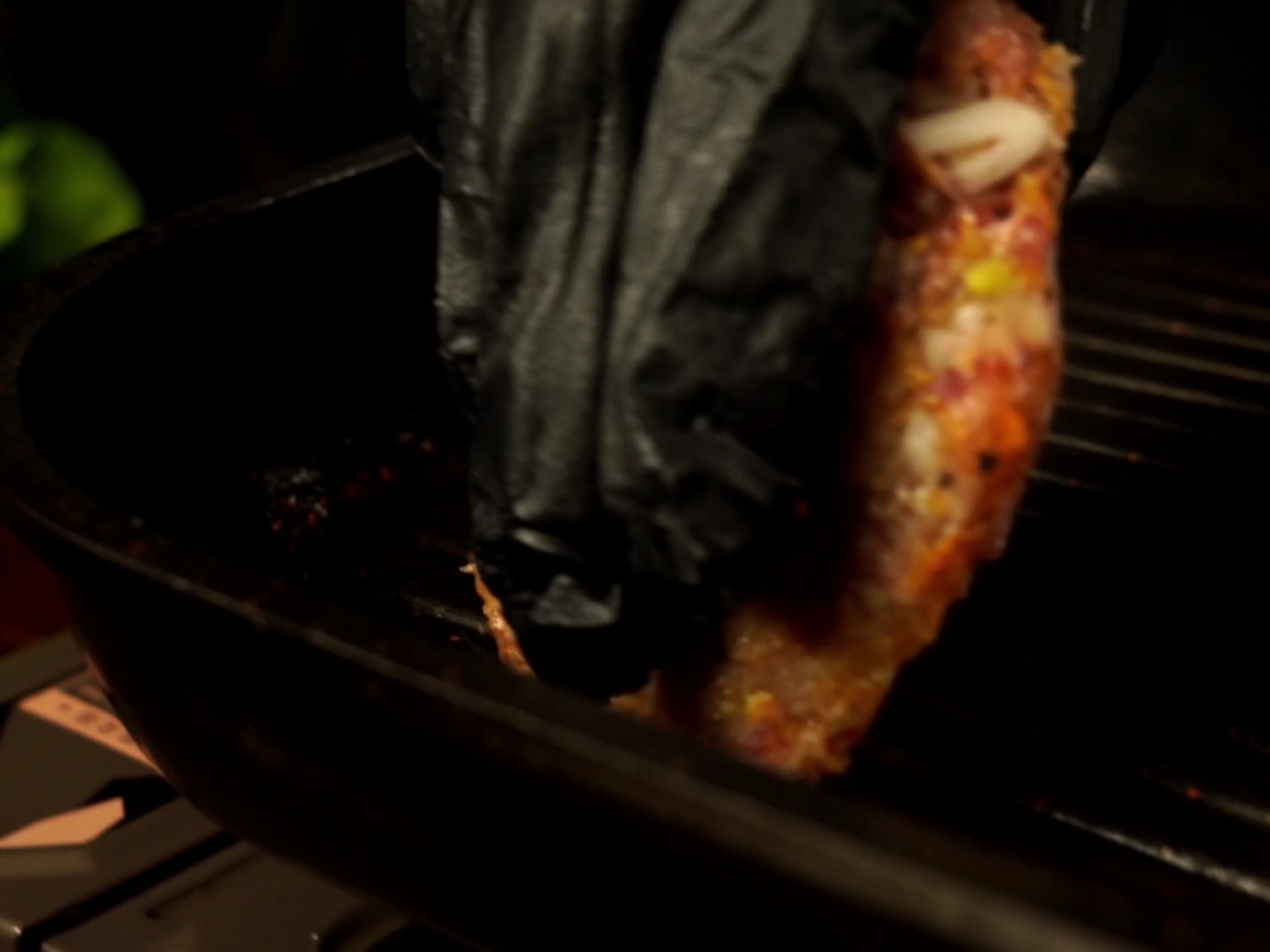 Un steak de bœuf cru déposé dans une poêle grill préchauffée.