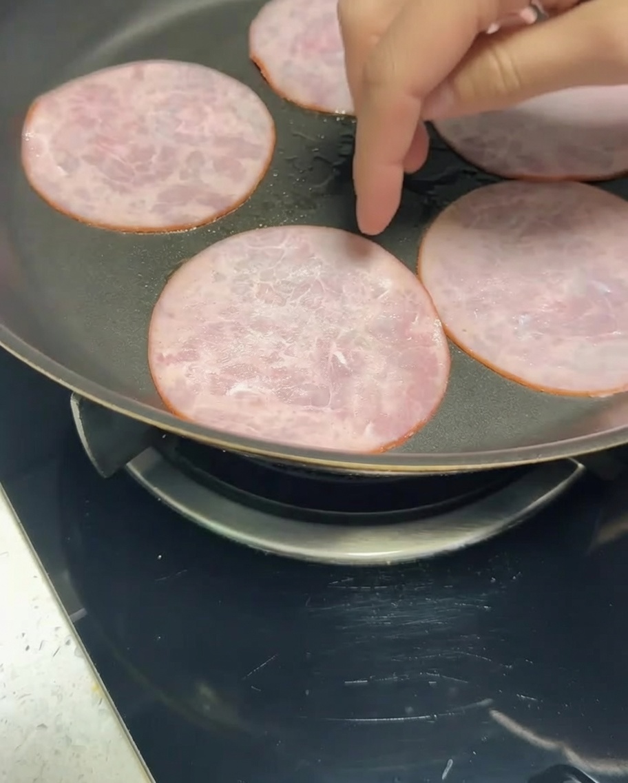 Tranches de bacon allégé dorant à la poêle.